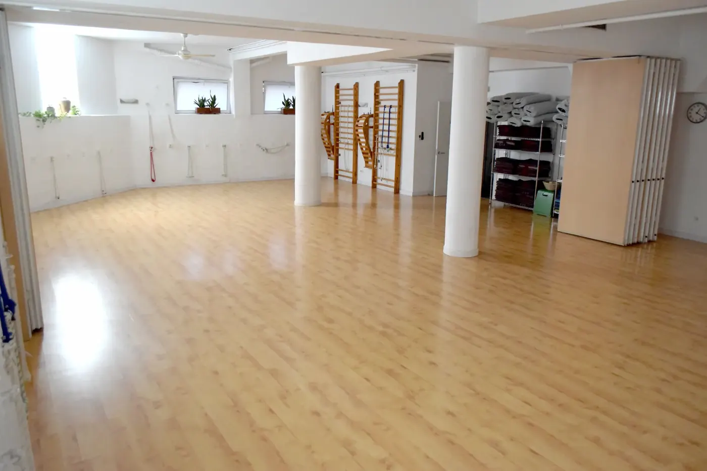 Sala amplia y luminosa de City Yoga en Cuatro Caminos, Madrid, con suelo de madera y espalderas